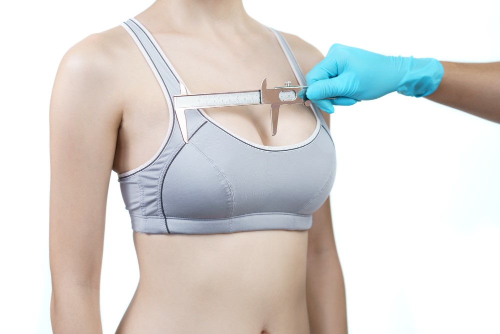 doctor-hand-measurement-woman-breast-with-caliper-breast-implant-surgery-concept
